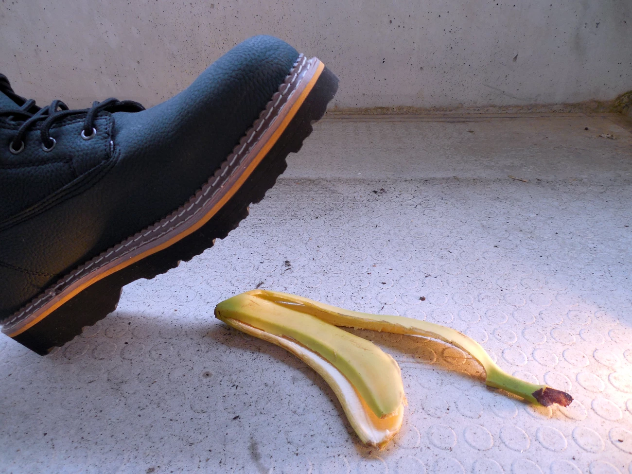 A persons work boot about to step on banana peel