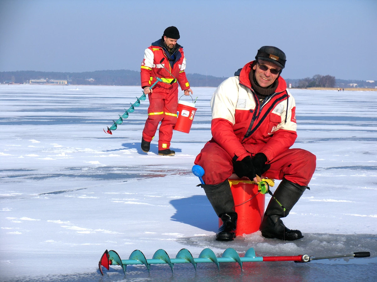 Two men ice fishing on a frozen lake